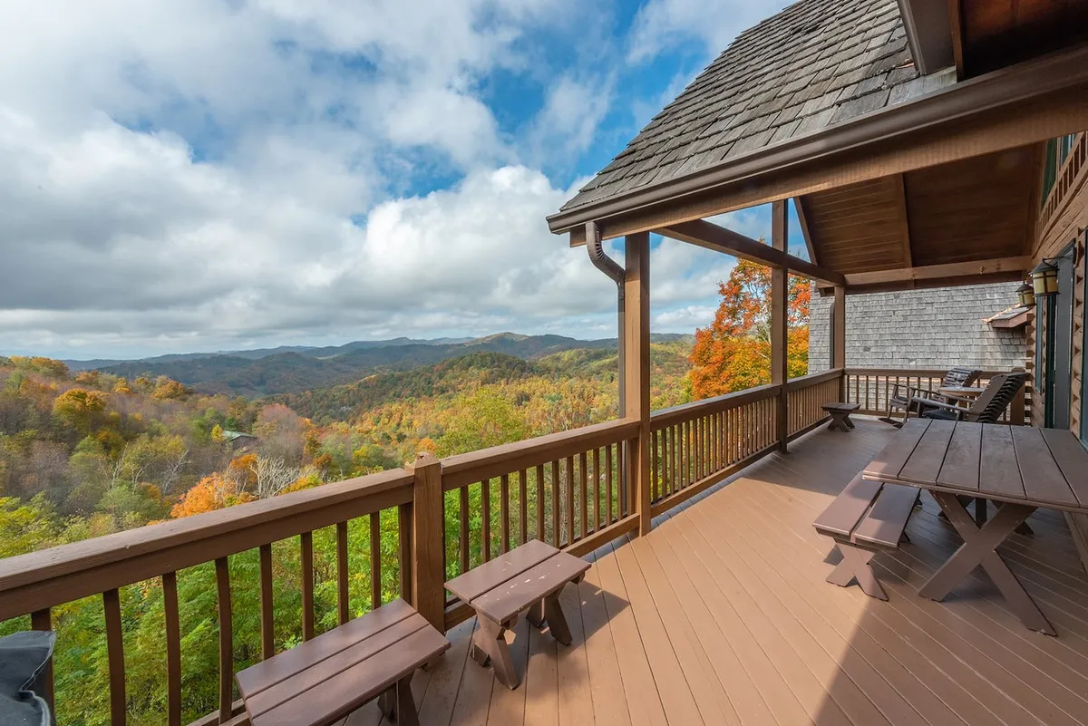 A wooden deck featuring comfortable outdoor seating, with the mountains stretching into the distance. The inviting setup encourages sipping morning coffee or gathering with friends while enjoying the peaceful ambiance of nature.